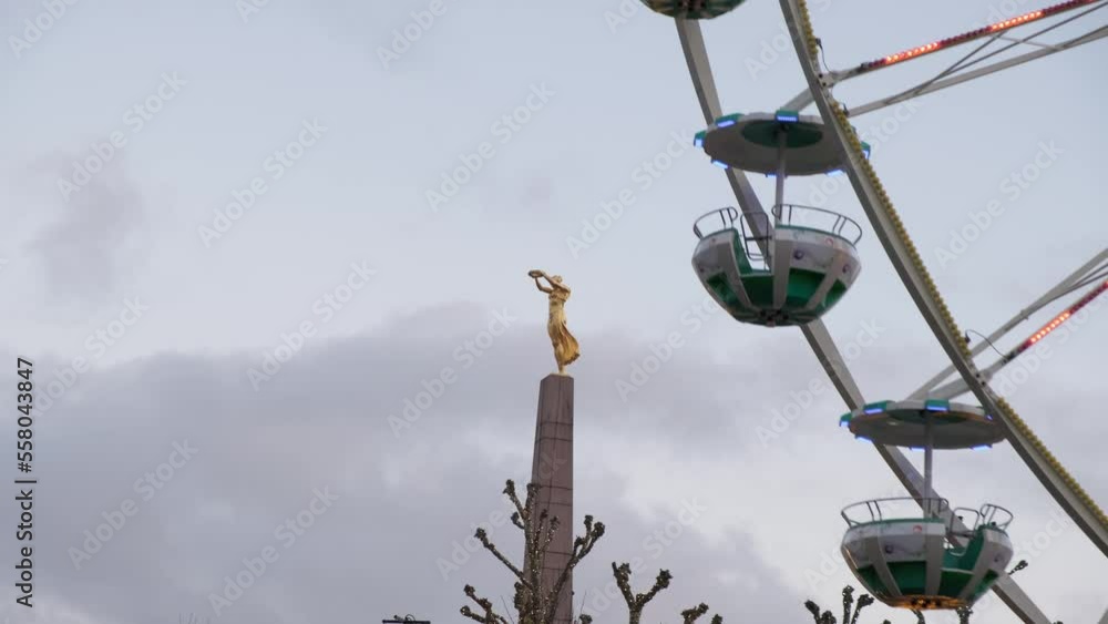 Ferris wheel next to Golden Lady statue in Christmas time in city centre of Luxembourg Ferris wheel next to Golden Lady statue in Christmas time in city centre of Luxembourg