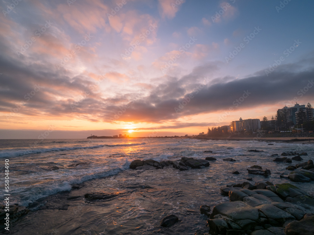 Obraz premium Coastal Sunrise with Waves Crashing