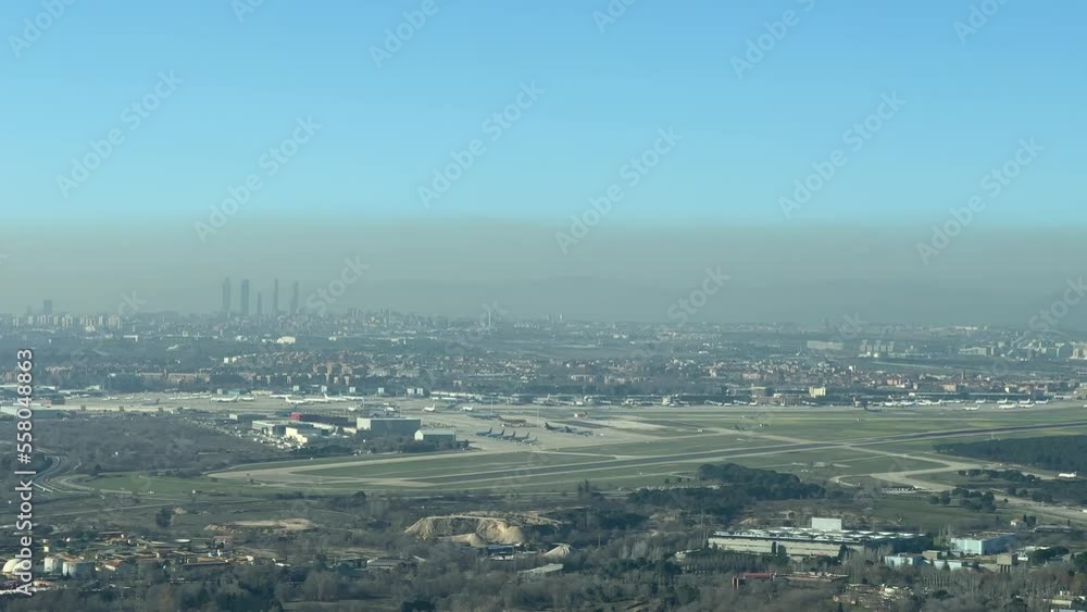 Dramatic view of the pollution over Madrid city in Spain due to winter high pressures, with a side view of the international Barajas airport, from a jet cockpit during approach. Pilot point of view. Dramatic view of the pollution over Madrid city in Spain due to winter high pressures, with a side view of the international Barajas airport, from a jet cockpit during approach. Pilot point of view.