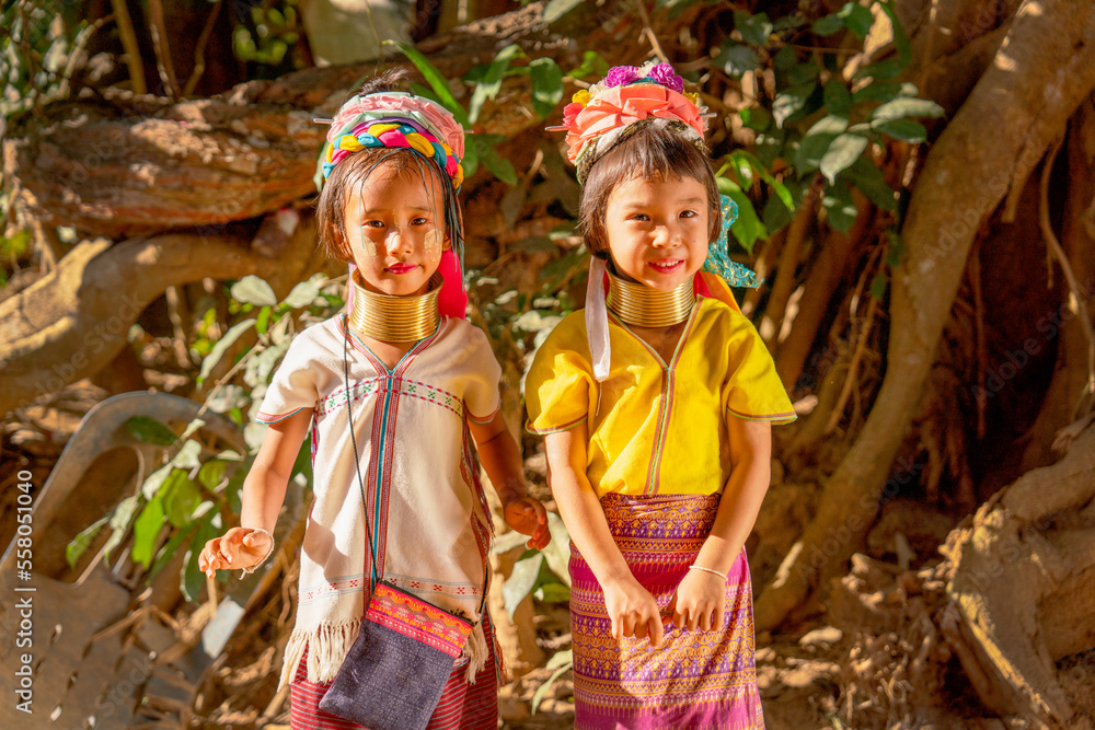 Little Asian Long Neck Karen girls stand beside and look to camera with smiling express happiness during play around in the village.