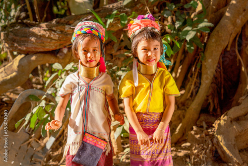 Little Asian Long Neck Karen girls stand beside and look to camera with smiling express happiness during play around in the village.