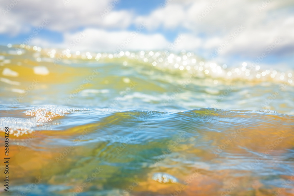 A close-up of the sea water surface in soft focus. The sea in the light of the sun's rays in the hot summer. Background on the theme of serenity, travel and beach vacation. A close-up of the sea water surface in soft focus. The sea in the light of the sun's rays in the hot summer. Background on the theme of serenity, travel and beach vacation.