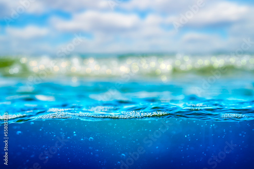 Background with sea water and selective focus on the underwater part with bubbles. A three-part nautical theme template with a blank space for text.
