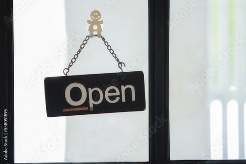 Welcome open sign on shop door. Text on cafe front or restaurant hang on door at entrance.