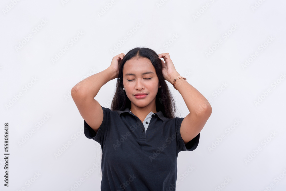 An optimistic young woman closing her eyes and stroking her hair. Isolated on a white background. An optimistic young woman closing her eyes and stroking her hair. Isolated on a white background.