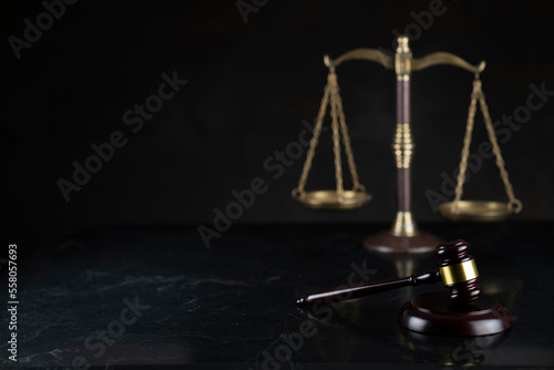 Law symbols composition. Gavel, scale and Themis sculpture on dark brown background.