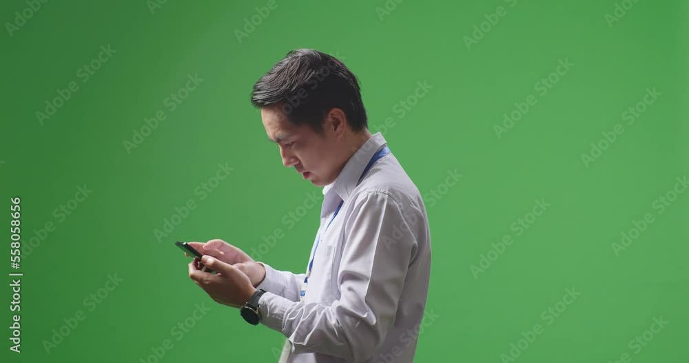 Side View Of Happy Asian Business Man Celebrating Using Mobile Phone On Green Screen In The Studio
Side View Of Happy Asian Business Man Celebrating Using Mobile Phone On Green Screen In The Studio