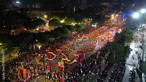 Top view of dragon dance perform celebration new year. Group of people perform a traditional lion dance and dragon dance. Guinness record performance of 54 Dragons dance on the street Vung Tau. photo