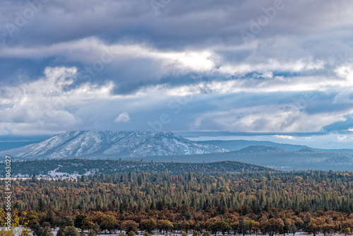 Autumn foliage is visible below Widow Mountain, covered in clouds, in Lassen County, California, USA © davidrh