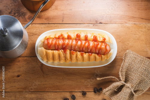 A hot dog, Bun with grilled sausage with tomato ketchup served on white plate for breakfast or appetizer dish.