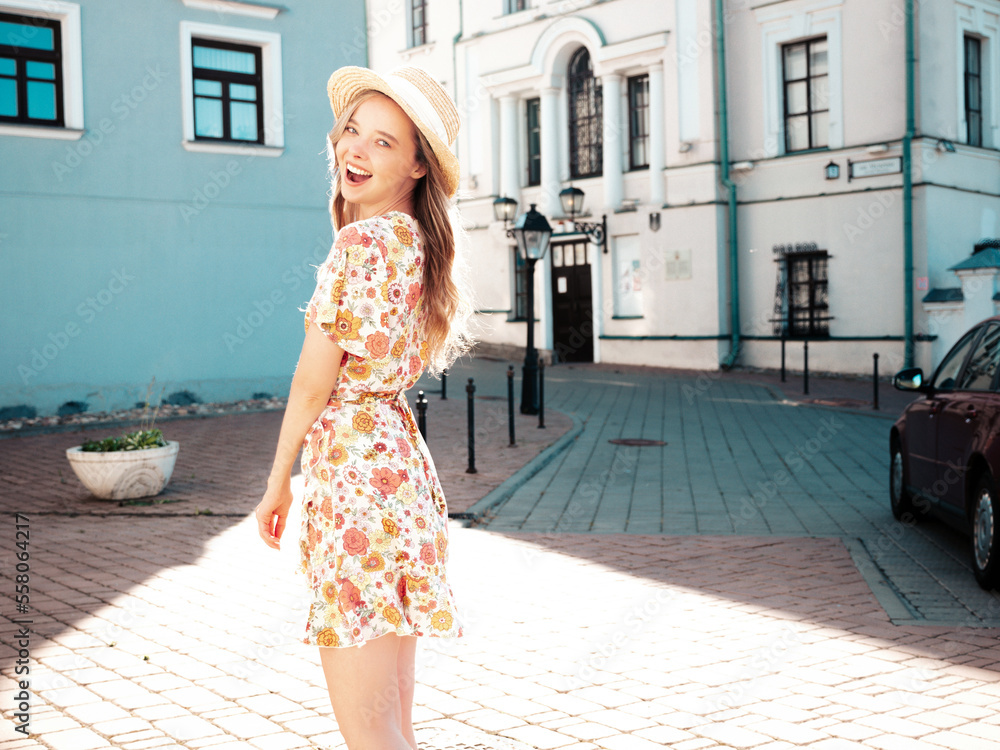 Naklejka premium Young beautiful smiling hipster woman in trendy summer clothes. Sexy carefree woman posing on the street background at sunset. Positive model outdoors. Cheerful and happy. In hat