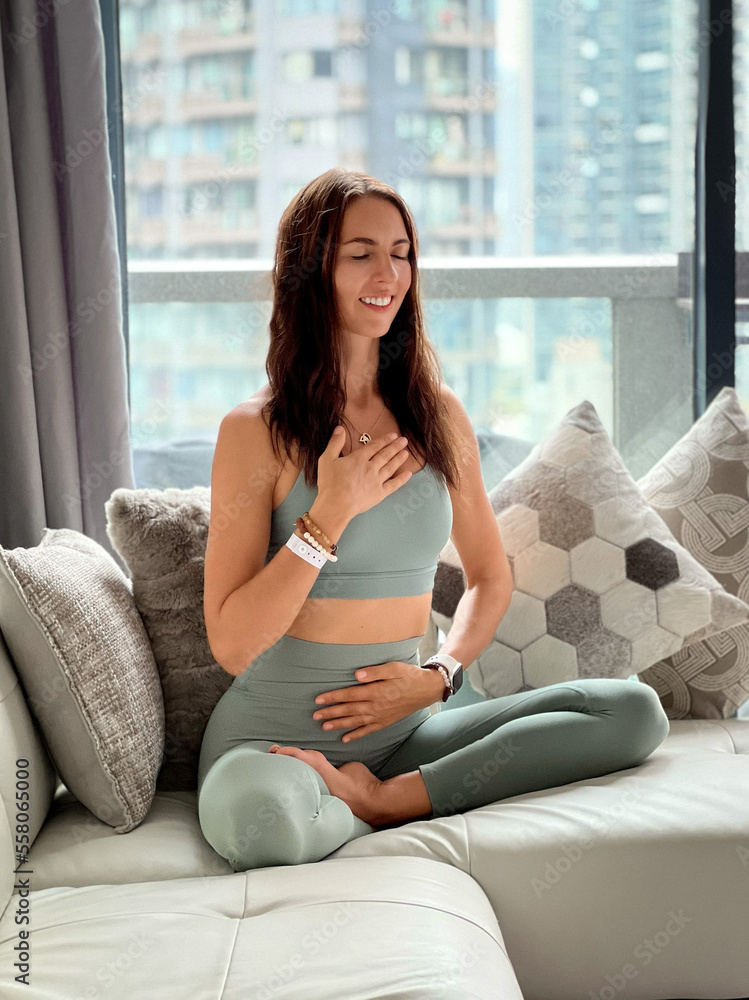 beautiful young happy smiling woman meditating at home on sofa in lotus pose, mindfulness meditation, relax, beautiful young happy smiling woman meditating at home on sofa in lotus pose, mindfulness meditation, relax,