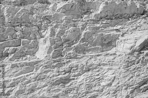Grungy cragged bumpy pitted cavity stone facade, split layer gap.Ruined cracked shattered worn rough hiking canyon.Old ragged grunge steep marble cliff. Grand vintage crannied damaged impressive gorge