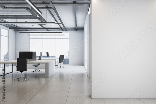 Front view on blank white wall with place for advertising poster in spacious office with monochrome interior design, light floor, loft ceiling lamps and big window background. 3D rendering, mockup