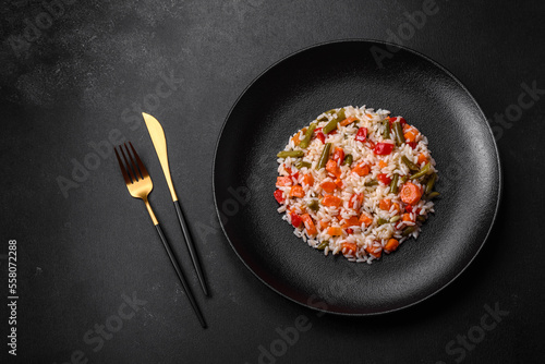 Delicious fresh risotto with vegetables, spices and herbs on a black plate