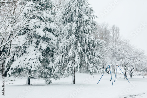 Child swing set dusted with snow in a snow covered parkland
