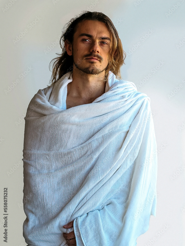 Beautiful bearded man in white robe resembles Christ Jesus