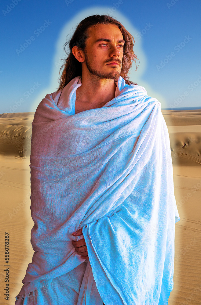 Holy, handsome man with a halo in white robe in desert - looks like Jesus
