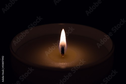 Candle flame in glass laid on dark place in the night
