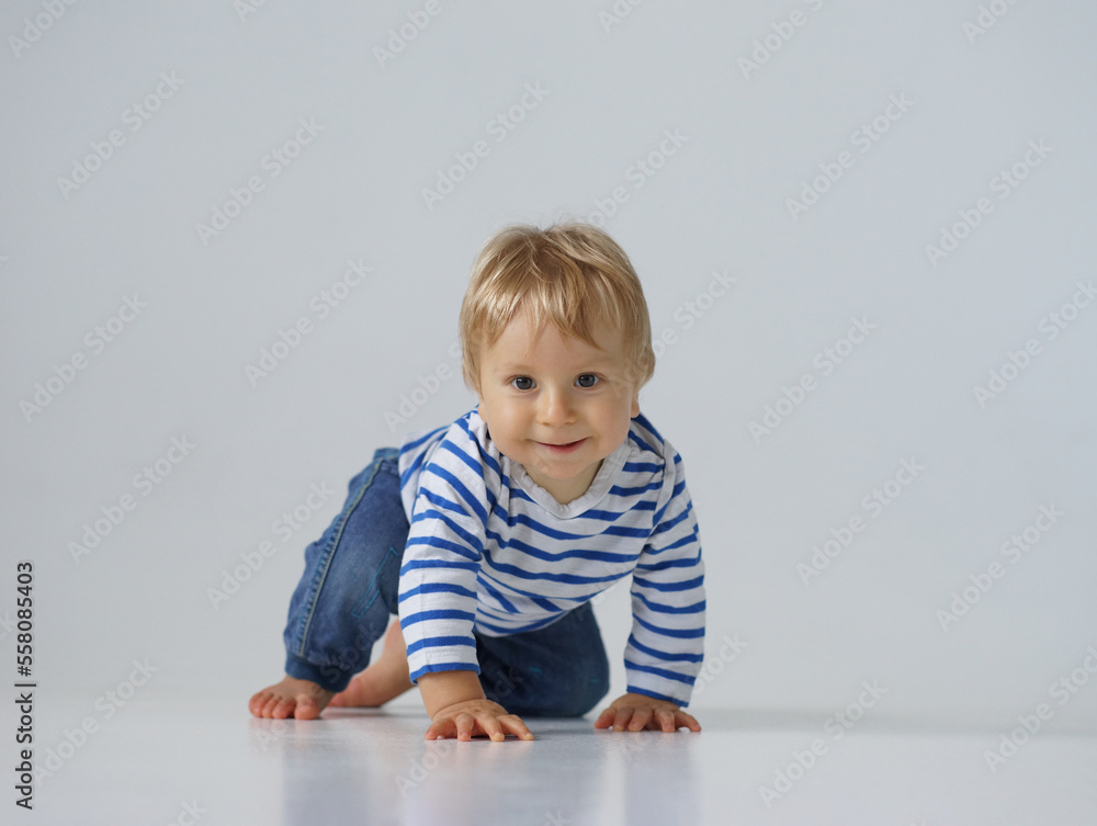 Little, happy and smiling cute baby in the studio. Portrait of a one year old baby. The concept of happiness. Little, happy and smiling cute baby in the studio. Portrait of a one year old baby. The concept of happiness.