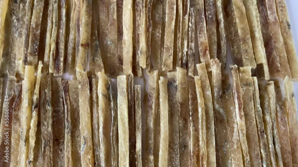 Dried salted tuna meat sliced or stacked on white background. An elite beer snack. Close-up. Dried salted tuna meat sliced or stacked on white background. An elite beer snack. Close-up.