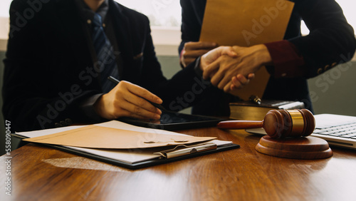 Business and lawyers discussing contract papers with brass scale on desk in office. Law, legal services, advice, justice and law concept picture with film grain effect