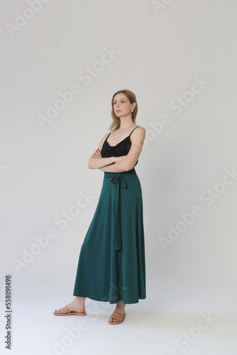 Serie of studio photos of young female model in comfortable yet stylish cotton outfit, black shit and emerald green skirt.