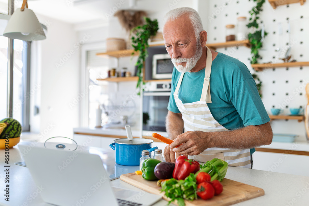 Happy senior man having fun cooking at home - Elderly person preparing health lunch in modern kitchen - Retired lifestyle time and food nutrition concept Happy senior man having fun cooking at home - Elderly person preparing health lunch in modern kitchen - Retired lifestyle time and food nutrition concept
