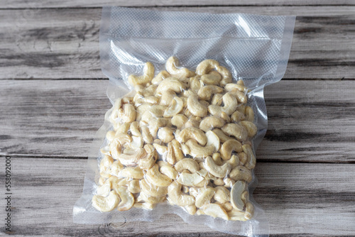 Vacuum-packed dried cashews on a wooden background. Plant-based diet, healthy fats, keto diet, lchf photo