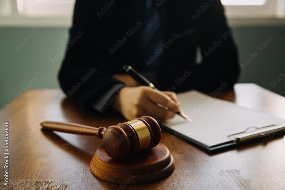 Business and lawyers discussing contract papers with brass scale on desk in office. Law, legal services, advice, justice and law concept picture with film grain effect Business and lawyers discussing contract papers with brass scale on desk in office. Law, legal services, advice, justice and law concept picture with film grain effect