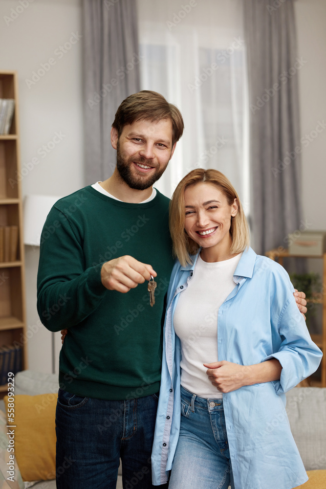 Happy Couple Holding Key. Happy Young Family Holding Key To New Home On Moving Day. Real Estate Owners Embrace Proud Buying Property Happy Couple Holding Key. Happy Young Family Holding Key To New Home On Moving Day. Real Estate Owners Embrace Proud Buying Property