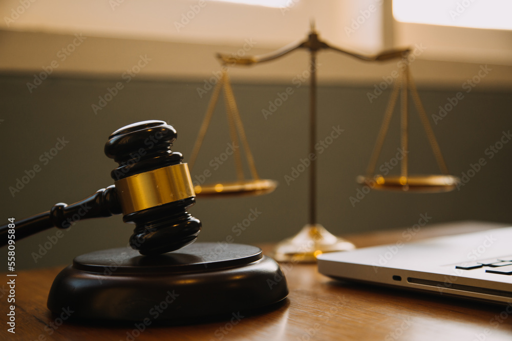 Business and lawyers discussing contract papers with brass scale on desk in office. Law, legal services, advice, justice and law concept picture with film grain effect Business and lawyers discussing contract papers with brass scale on desk in office. Law, legal services, advice, justice and law concept picture with film grain effect