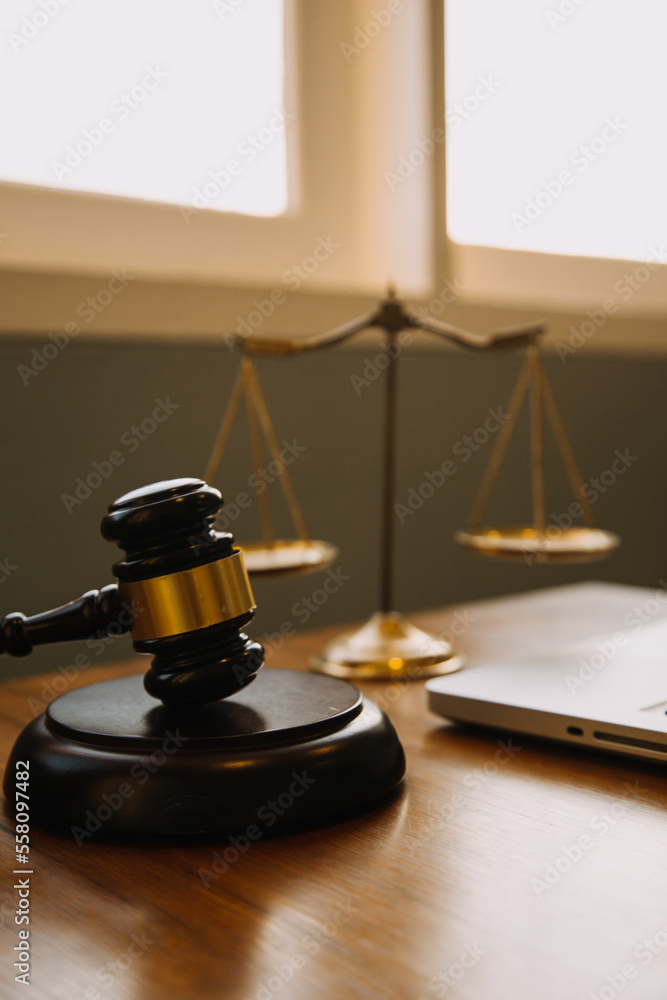Business and lawyers discussing contract papers with brass scale on desk in office. Law, legal services, advice, justice and law concept picture with film grain effect Business and lawyers discussing contract papers with brass scale on desk in office. Law, legal services, advice, justice and law concept picture with film grain effect
