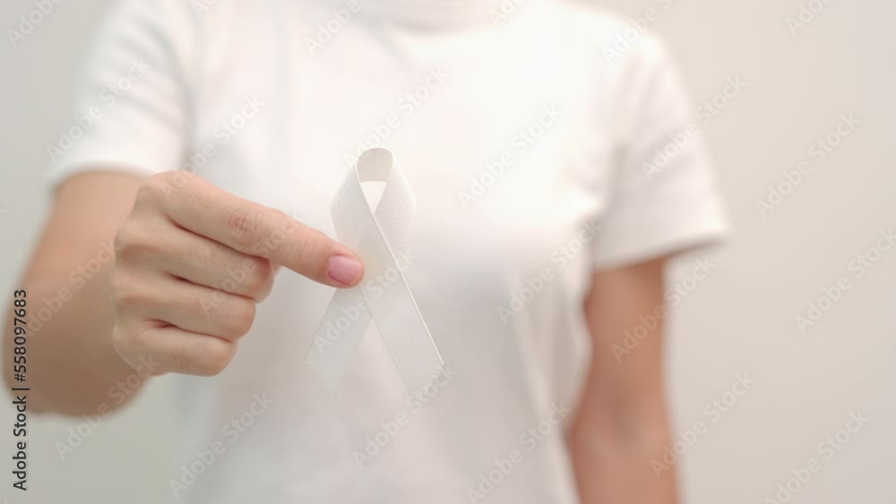 Woman holding white Ribbon for November Lung Cancer Awareness month, democracy and international peace day. Healthcare concept Woman holding white Ribbon for November Lung Cancer Awareness month, democracy and international peace day. Healthcare concept
