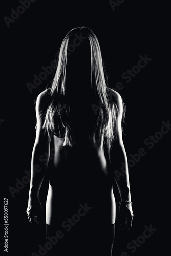 retrato en clave baja de una mujer de frente a la camara sobre fondo negro y en blanco y negro