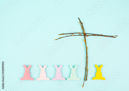 Easter bunny or rabbit with a religious cross made from willow branches, christian spring holiday, greeting card 
