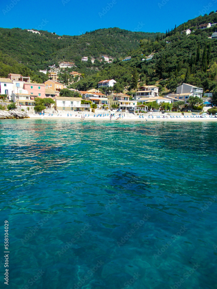 small pretty Mediterranean village resort on coast . Colourful villa taverna beach and blue sea perfect holiday vacation summer destination.