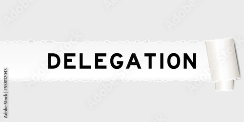 Ripped gray paper background that have word delegation under torn part