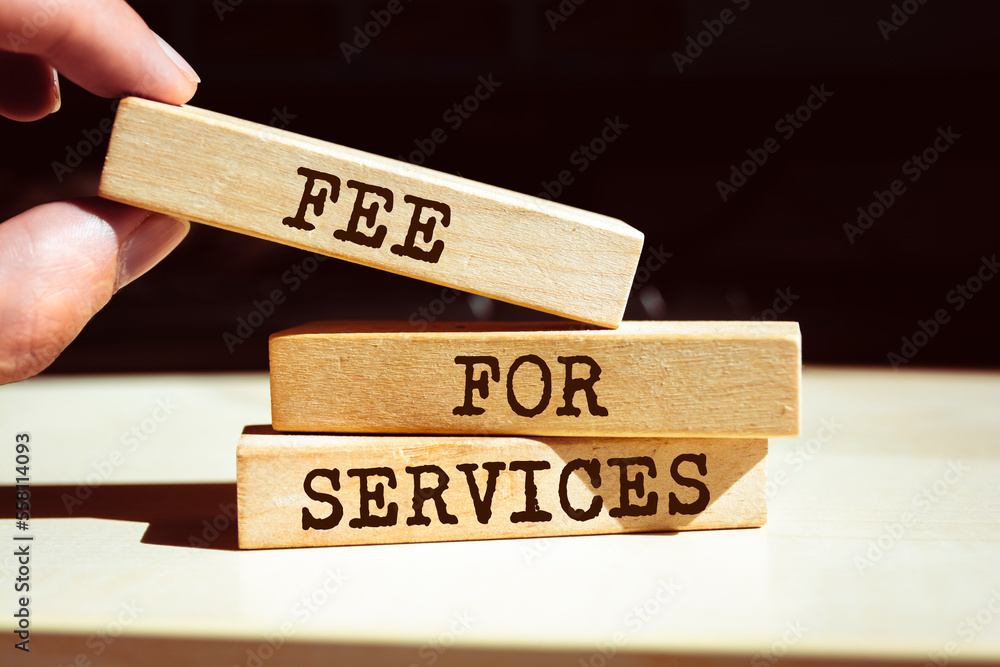 Closeup on businessman holding a wooden blocks with text FEE FOR SERVICES, business concept Closeup on businessman holding a wooden blocks with text FEE FOR SERVICES, business concept