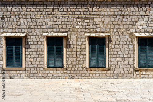 Green windows on a brick wall