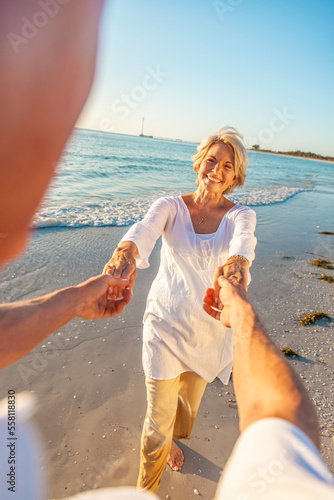 Happy Old Retired Senior Couple Dancing Holding Hands on a Beach