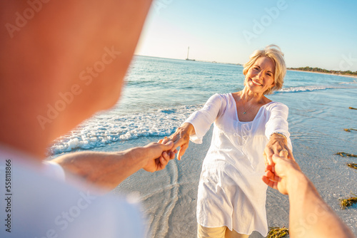 Happy Senior Old Retired Couple Dancing Holding Hands on a Beach