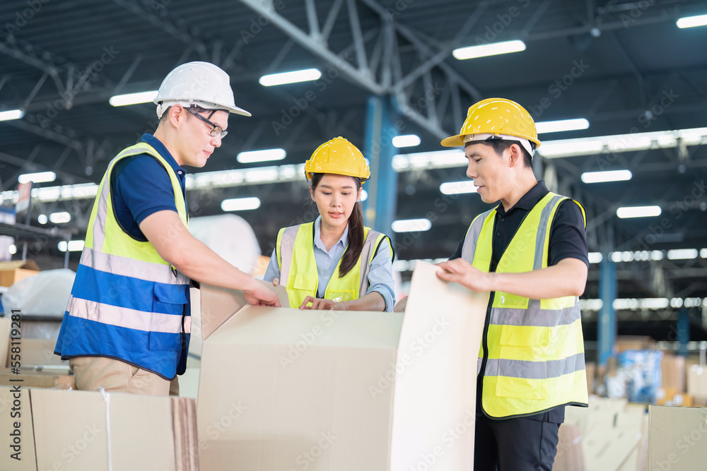 Staff in large storage warehouse together packing goods and carry carton box on pallet Staff in large storage warehouse together packing goods and carry carton box on pallet