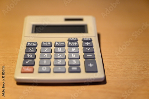 Electronic calculator on a desk. Basic solar desk calculator representing old technology. Focus on number 8 with shallow depth of field. No logo or branding.