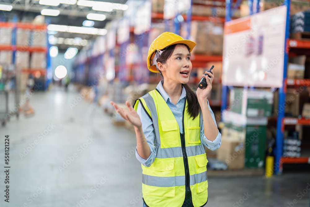 Staff in large storage warehouse use radio walkie talkie explain material storage location to team Staff in large storage warehouse use radio walkie talkie explain material storage location to team