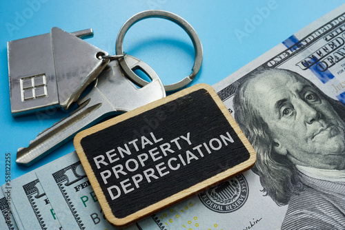 Key, cash and plate with sign Rental property depreciation.
