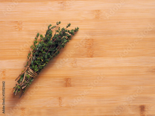 Bundle of fresh thymes on a wooden background