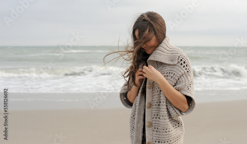 Young brunette woman portrait dressed knitted sweater, hiking near the ocean
