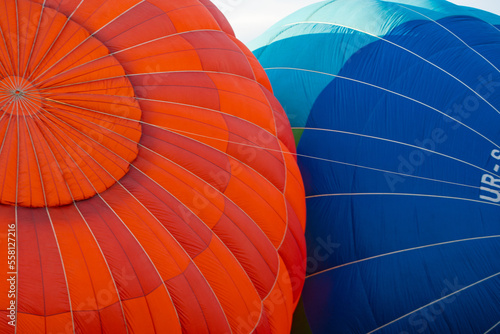 blue and red balloons lie being inflated on the ground before flying. Close-up
