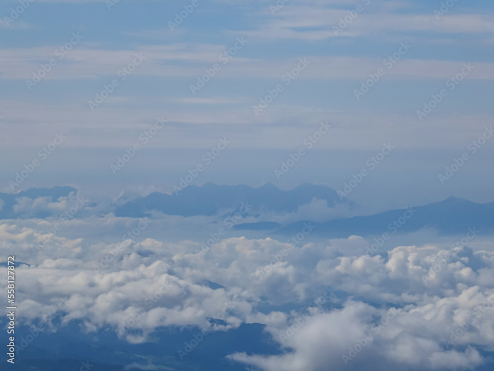 Panoramic aerial view of the cloud covered Karawanks (Karawanken) and Julian Alps seen from mountain peak of Zirbitzkogel, Seetal Alps, Styria, Austria, Europe. Alpine landscape cloudy moody day